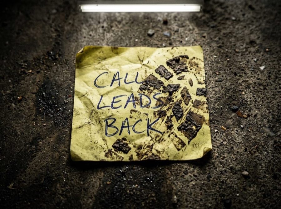A sticky note fallen behind a desk